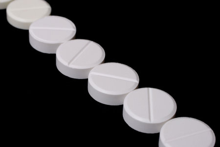 White  pills  in close up isolated on black background
