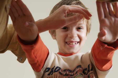 Young boy smiling and gesturing with mother handの写真素材