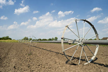 Cultivated field after seeding with irrigation system whealの写真素材