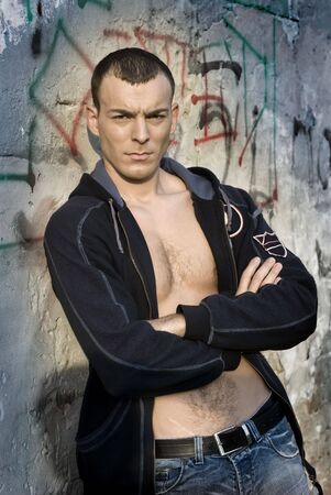 Shirtless muscular male model in front of the wallの写真素材