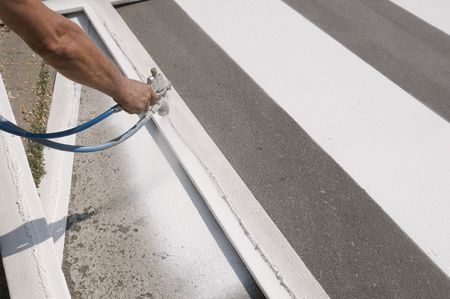 Hand spraying of pedestrian crosswalk at a streetの写真素材