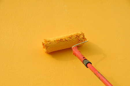 Painting of orange wall with paint roller