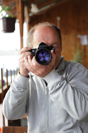 Middle age photographer taking picture with his digital camera