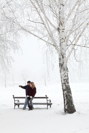 Teenage couple having fun at snow in parkの写真素材