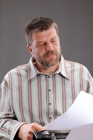 Middle age writer, clerk or journalist looking to paperの写真素材