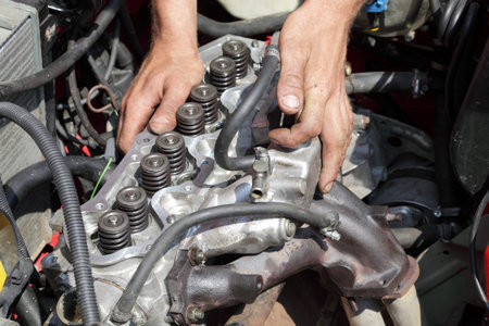 Repairing of modern gasoline engine, workers hands and engine head
