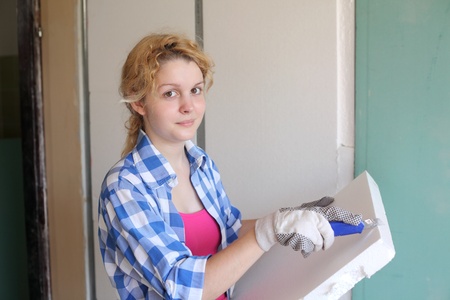 Young girl  with tool in hands working at home improvementの写真素材