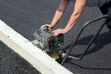Worker with compactor at a road construction siteのeditorial素材