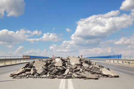 Damaged asphalt road and bridge in reconstructionの写真素材