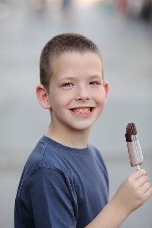 Smiling young Caucasian boy holding ice cream, real peopleの写真素材