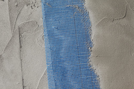 Closeup of layers over styrofoam insulation, mesh, plaster, cement, mortar