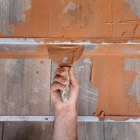 Joint sealing tiles, worker hand and trowel toolの写真素材