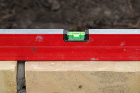 Closeup of brick wall control with level tool
