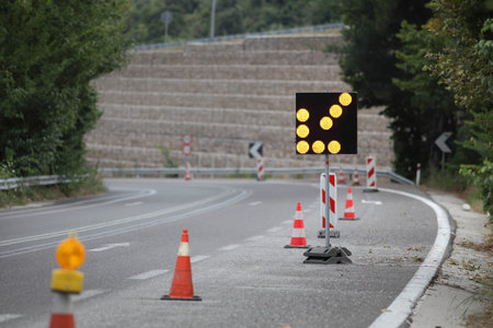 Roadworks, arrow traffic light and road signs at a road in Greece from Thessaloniki to Athens
