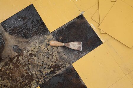 Old vinyl tiles removing from kitchen floor, spatula trowelの写真素材