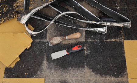 Old vinyl tiles and batten removing from kitchen floor, spatula trowel