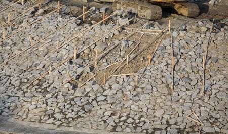 River or lake bank reconstruction using gravel, stones and concrete, construction site in late afternoonの写真素材