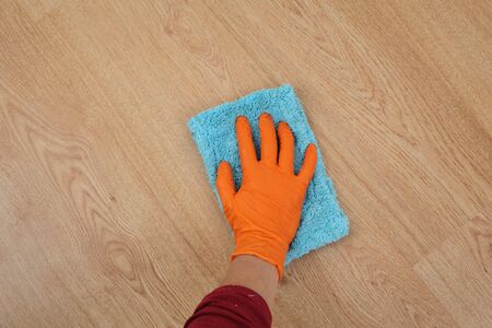 Laminate floor cleaning, closeup of hand in glove with ragの写真素材
