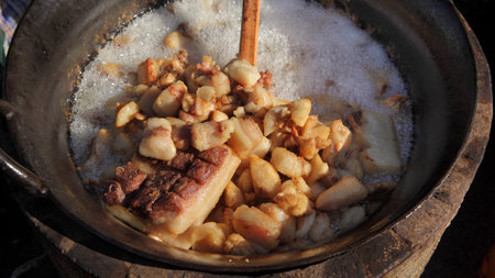 Pork greaves preparing in a big pot, tasty snacks in hot fat made from baconの写真素材