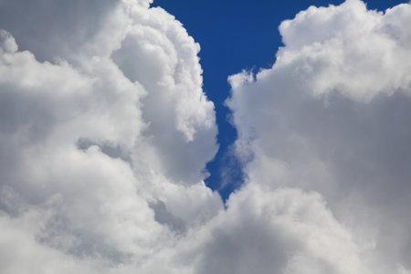 Telephoto closeup photo of dramatic clouds at blue sky