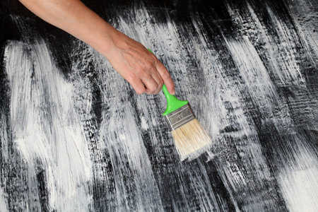 Home renovation, plank floor painting to white and black, shabby chic combination with workers hand...