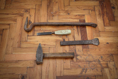 Tools for old damaged parquet removal, hammer, crowbar, chisel at old planksの写真素材