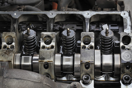 Detail of modern diesel engine repair, closeup of injectors in cylinder head with camshaft,...