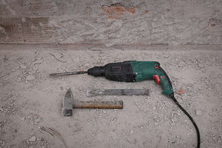 Tools for removal of old tiles and mortar from wall in a bathroom or kitchen, hammer, chisel and power  hammer drillの写真素材