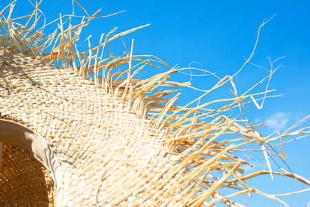 Straw hat on blue sky. Copy space for text. Themes of the world. The sun.の写真素材