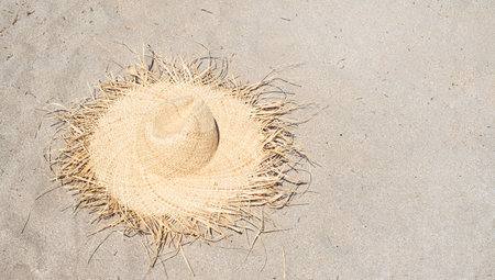 Straw hat on the sand. Beach themes. Production of hand weaving. Copy space for text.の写真素材