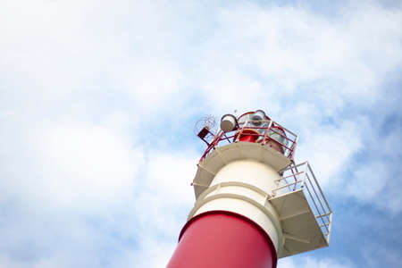 Lighthouse on the background of a blue sky with clouds. The stripes are white and red. bottom view.の写真素材