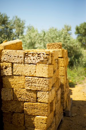 Shell rock bricks in a stack at a construction site.