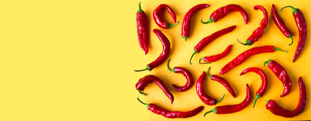 Yellow background with red peppers. Soap space for text. spice pattern.の写真素材