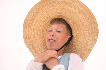 The face of a boy in a big straw hat. smile. Humor. trends. high quality photoの写真素材