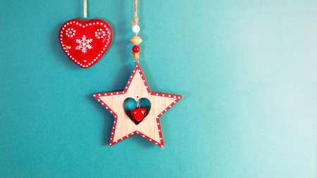 A wooden star with a bell and a ceramic red heart. Christmas decor. greeting card.の写真素材