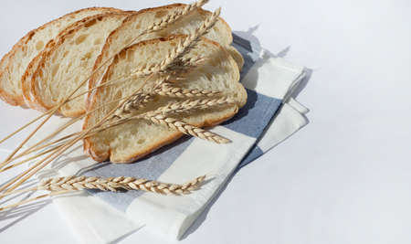 Pieces of bread and ears of wheat on a kitchen linen napkin. motherland. Bread production. Baker.の写真素材