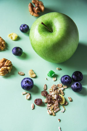 Green apple and muesli with dried fruit and blueberries.の写真素材