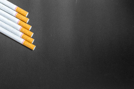 an unheatly cigarettes lying on the ground with black backgroundの写真素材