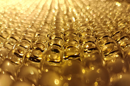 Golden bubbles shimmer under warm light, creating a mesmerizing abstract pattern.