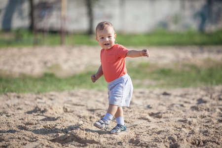 Little boy walking on the sand in the parkの写真素材
