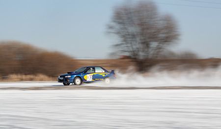Moscow, Russia - March 1st, 2014: Moscow Subaru Forester club championship. This stage was located in Moscow, on the frozen pond track. The track was build by club members. Man driving his blue subau Impreza on ice track, car sliding on the ice, snow. Panのeditorial素材