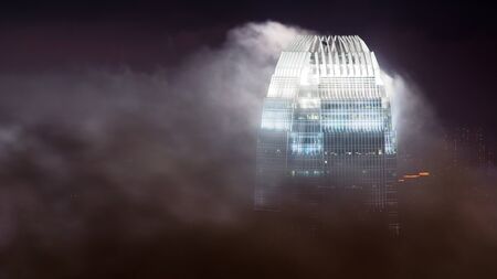 The  International Finance Centre in Hong Kong emerging from clouds, shot at nighttime のeditorial素材