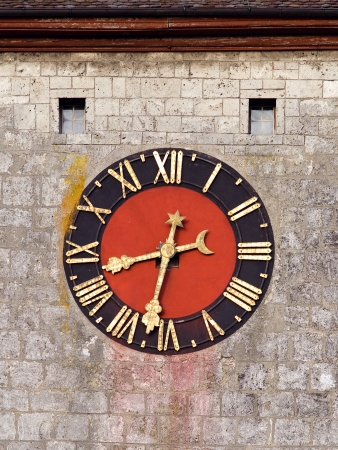 Medieval clock face on a tower with washed-out colors の写真素材