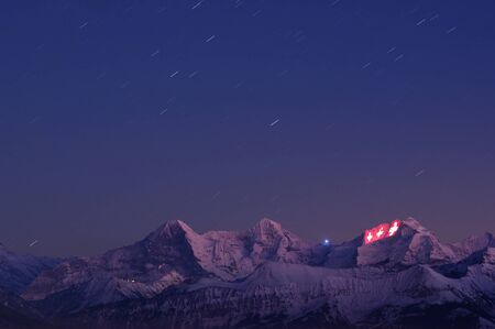 Thun, Switzerland - January 12, 2012: Three Swiss crosses being projected on the face of the Jungfrau as a part of the 100 year festivities of the Jungfrau railway.のeditorial素材