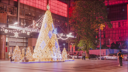 Unidentified people walking in front of a Christmas tree in Bangkok, Thailand.の写真素材