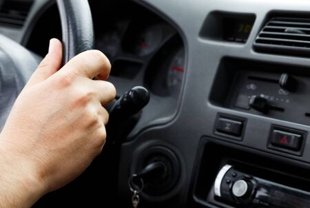Man driving a car with his hand on the steering wheelの写真素材