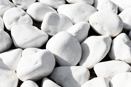 Background texture of smooth white stones or rocks used in landscaping and construction for decoration in a close up full frame viewの写真素材