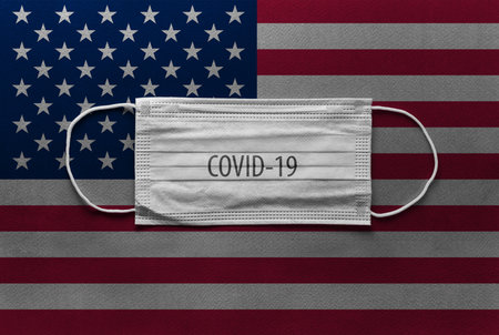 An individual face medical surgical mask on United State flag Background. Health mask. Protection...