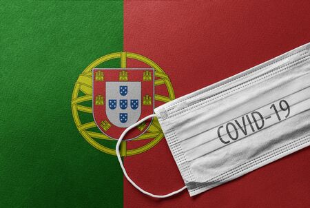 An individual face medical surgical mask on Portugal national flag Background. Health mask. Protection against COVID-19 virus, influenza, SARS. Save Portugal from Coronavirusの写真素材