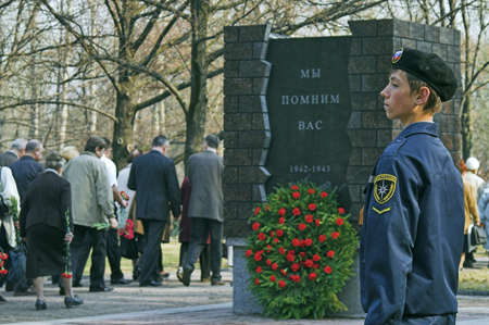 ST PETERSBURG - MAY 5: March in memory of WWII victims in city Victory Park. Schoolboy, 13, in scout uniform on honor guard May 5, 2008 in St Petersburg, Russia. Slogan on monument: We Remember Youのeditorial素材